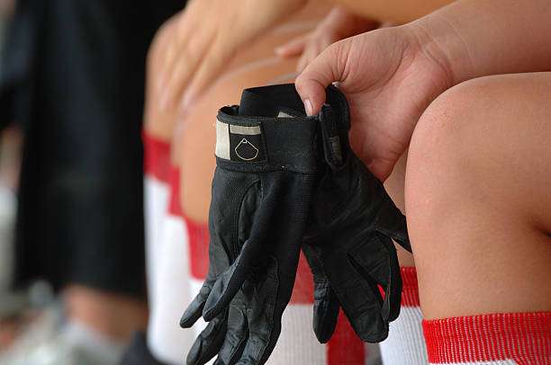 Close-up of black football gloves on a person's lap.
