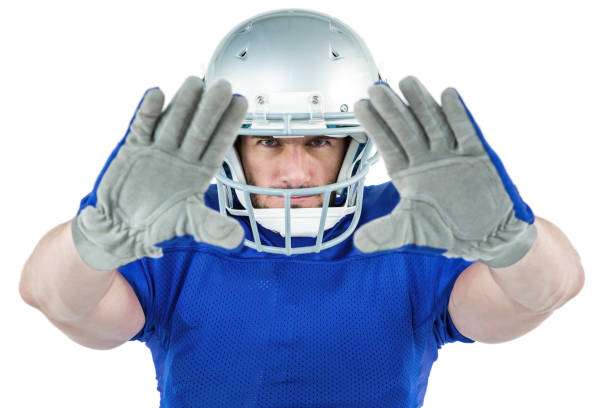 American football player in helmet and blue jersey showing grey football gloves.